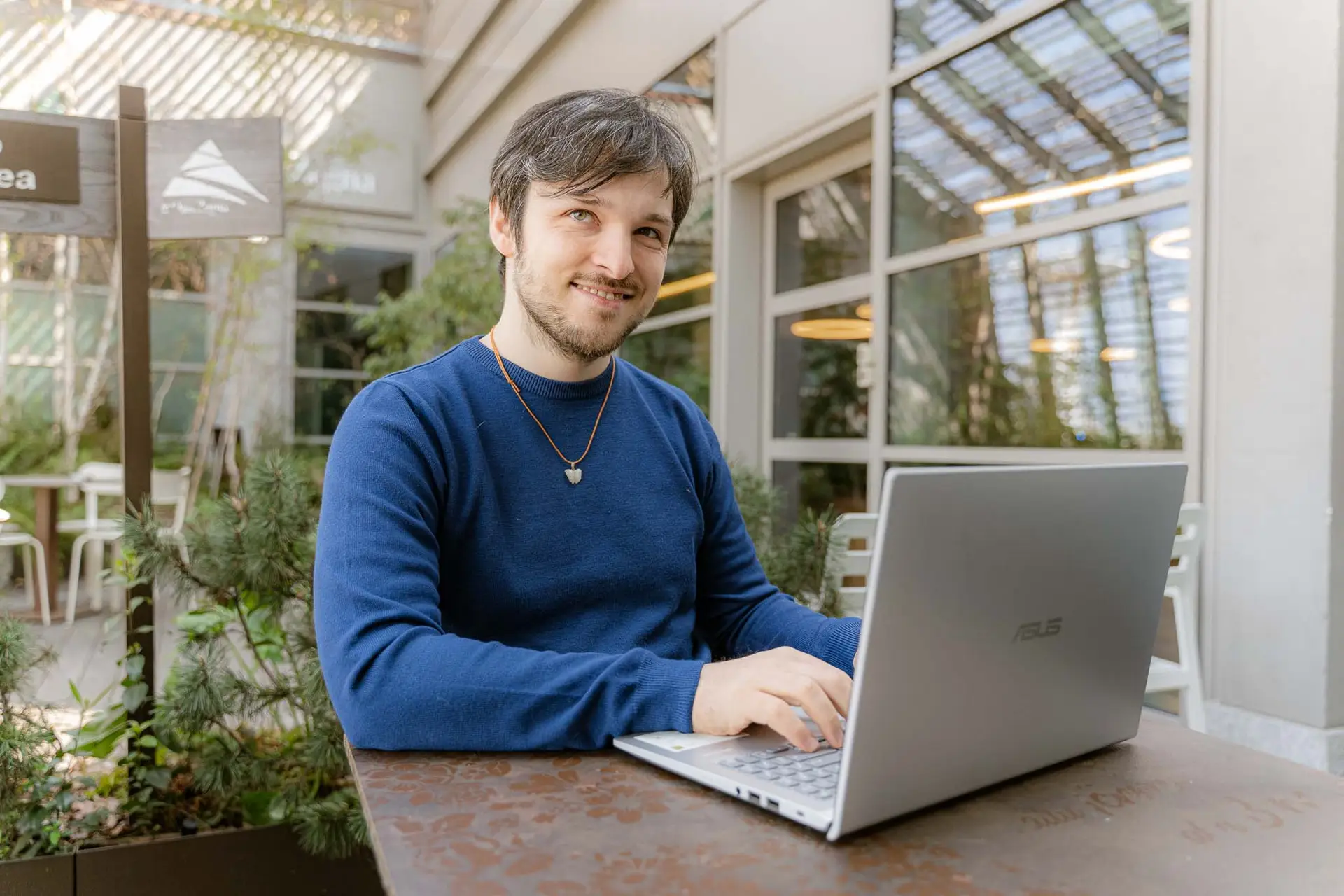 Davide riccio, toglie la testa dal pc di lavoro, mentre scriveva copy per un cliente, e guarda sorridente l'osservatore